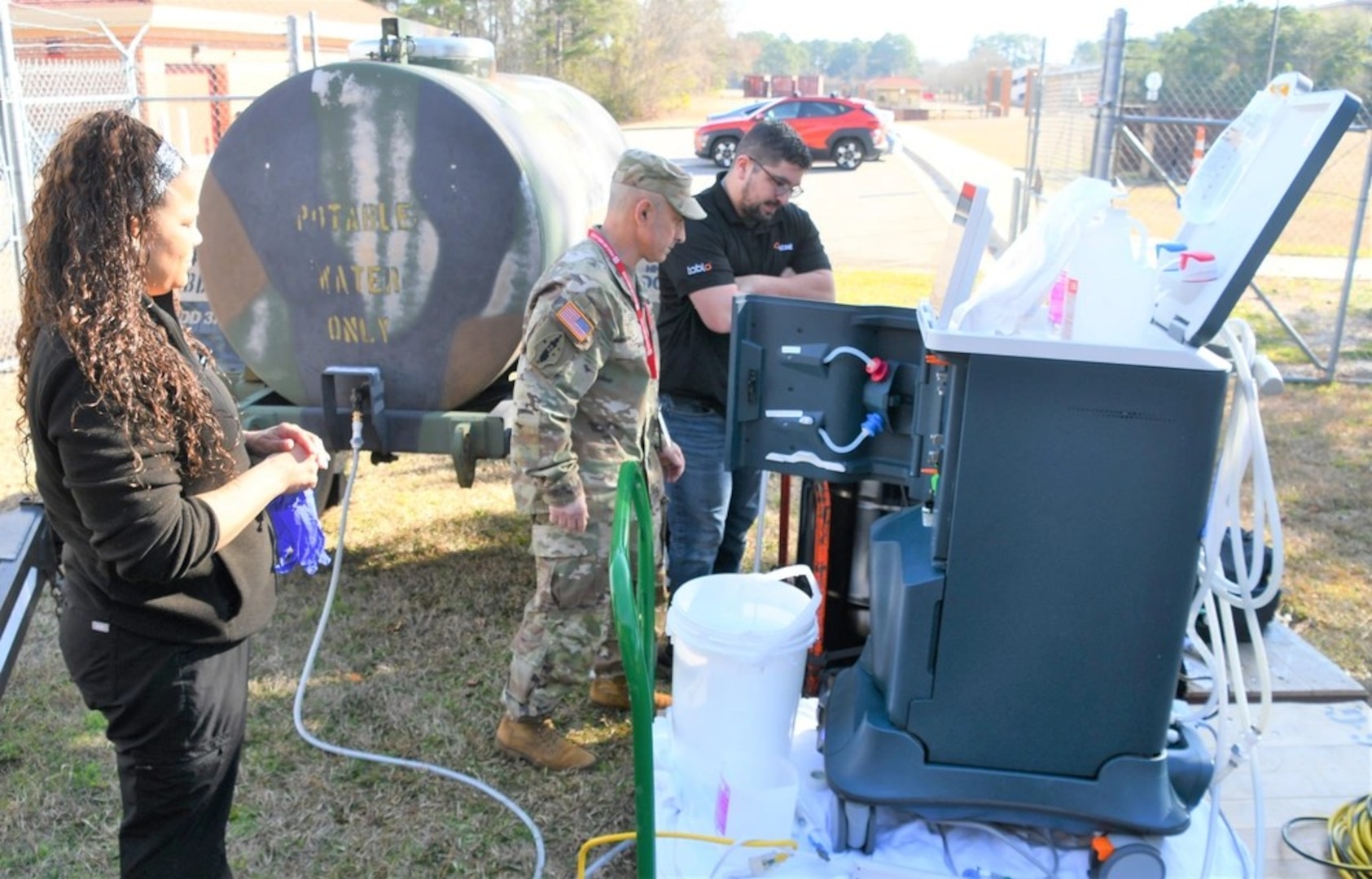 Tiffany Wise (L) and Dr. Robert Gaeta, Chief of Nephrology at Womack Army Medical Center (C) ensure that equipment is set up properly while testing to see if dialysis can be successful in an austere environment.