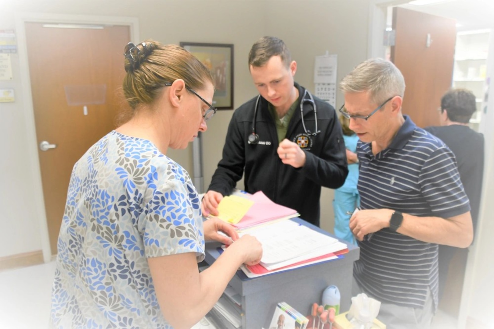 Cpt. Matthew Adair (C), a doctor at Womack Army Medical Center, looks over patient records with Dr. David Kersbergen (R) at the CARE clinic in Fayetteville on Tuesday, February 25th. Adair is among Womack’s resident doctors who volunteer at the CARE clinic on rotation.