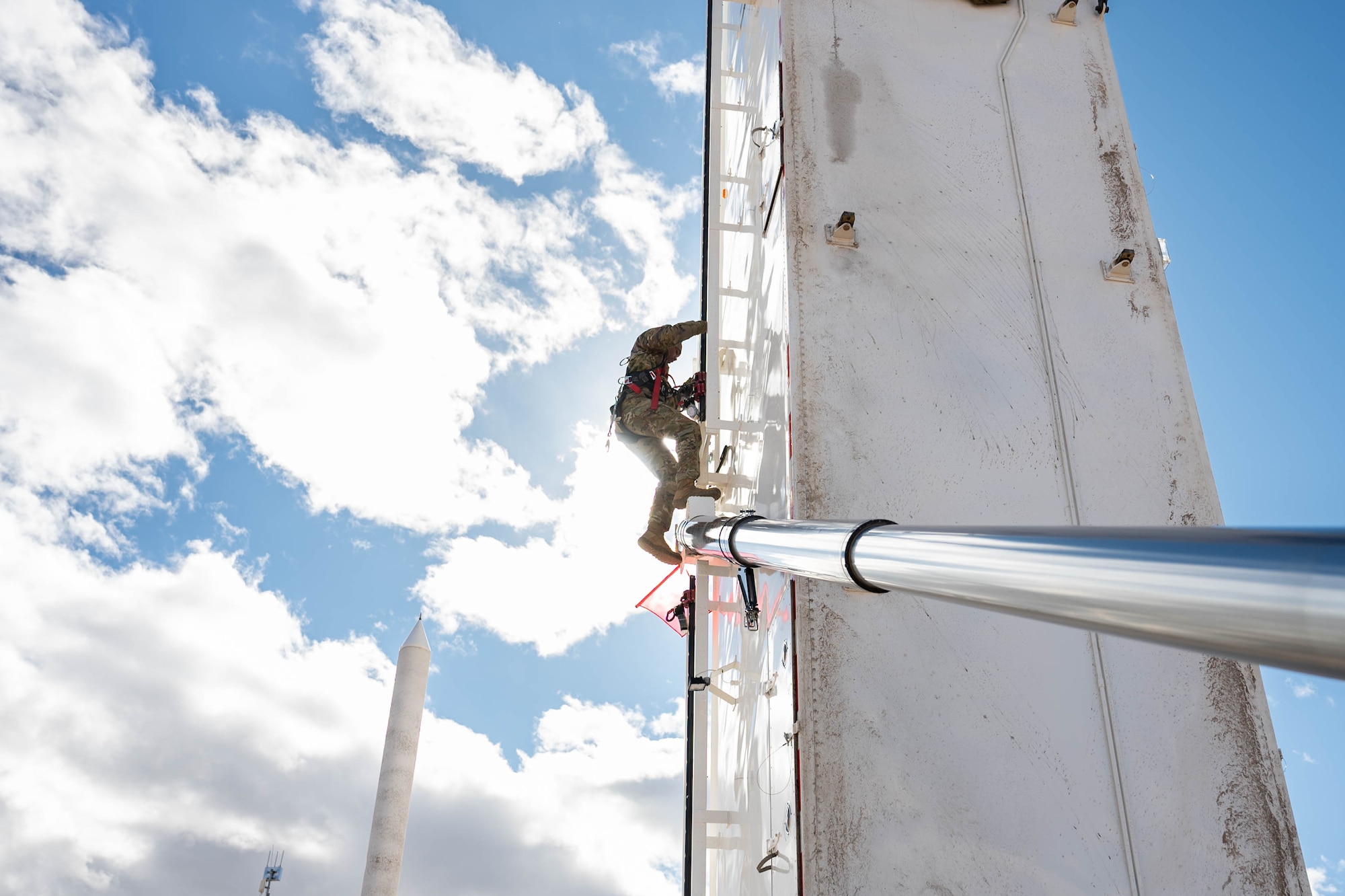 Man in uniform performs missile maintenance.