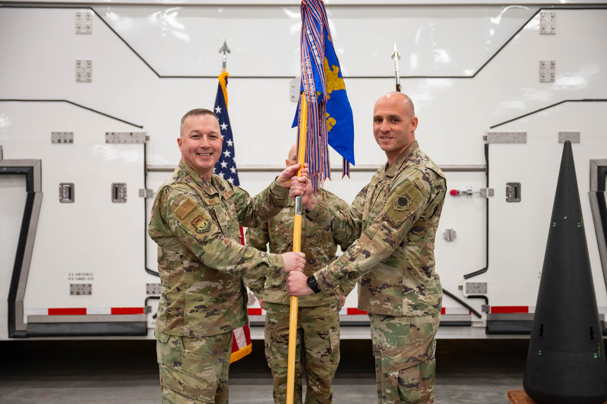 Men in uniform hold a flag.