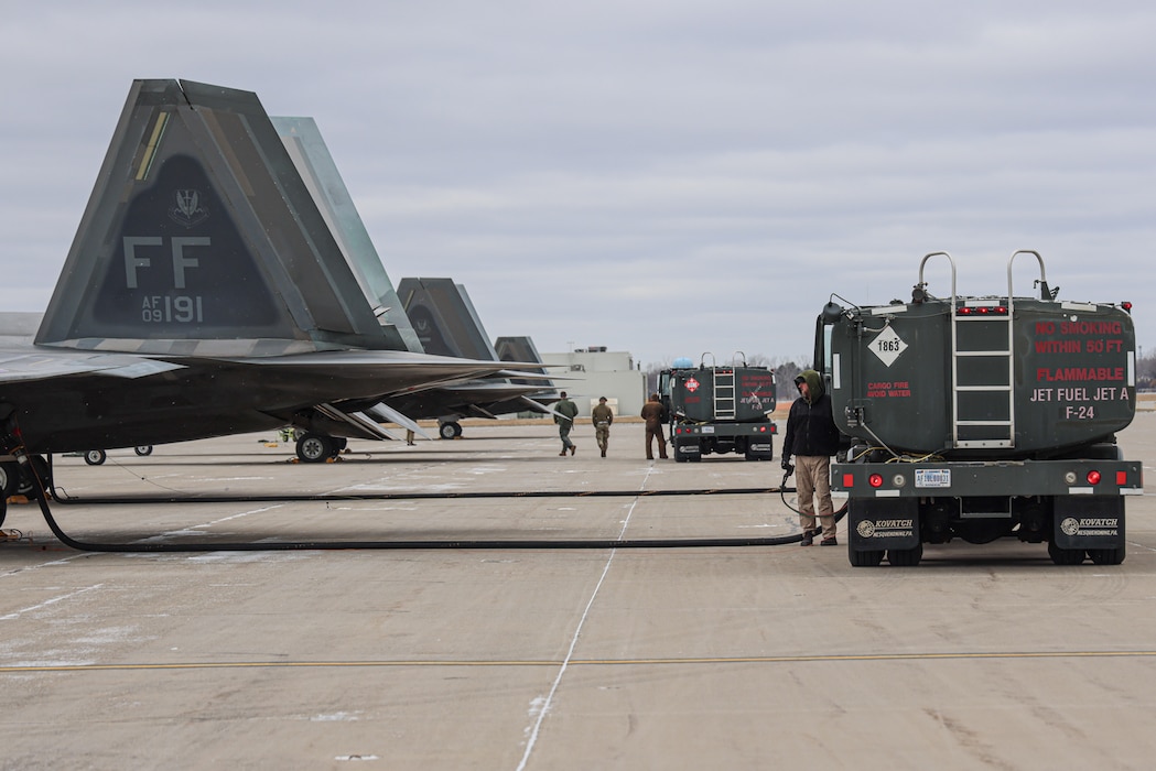 F22 Raptor aircraft tails and maintenance technicians on the flight line.