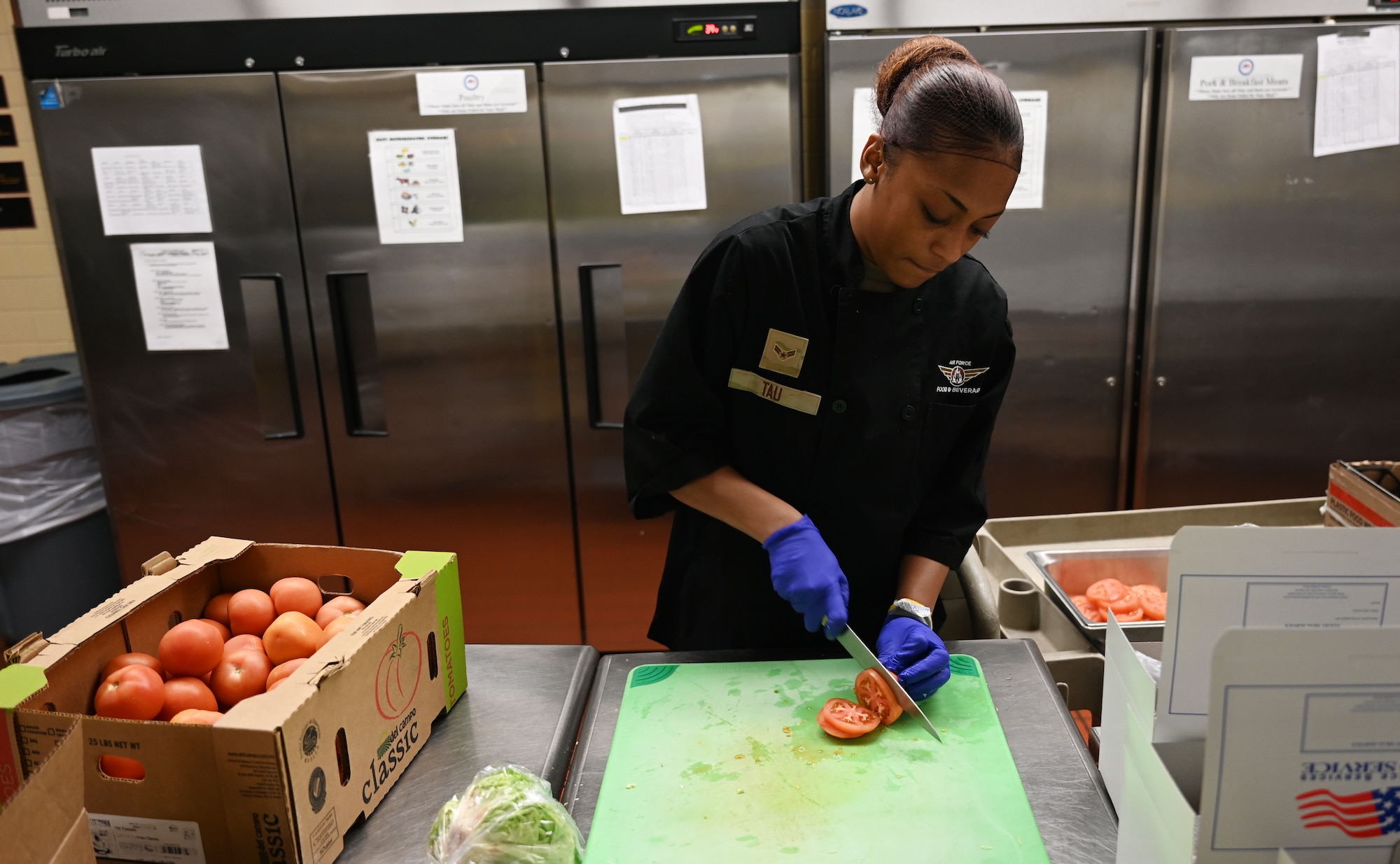 Airman slices tomatoes