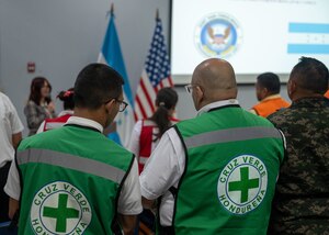 Two members from Honduran Green Cross stand for opening remarks during Jaguar Sentinel, a JTF-Bravo led tabletop exercise Feb. 28, 2025, Tegucigalpa, Honduras. Jaguar Sentinel is a forum for key players to share experience, capabilities and act as force multipliers during a crisis. (U.S. Air Force photo)