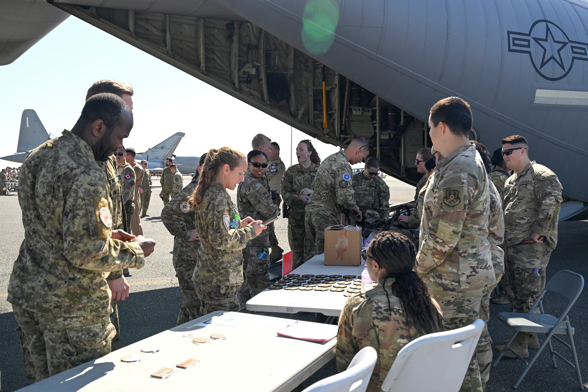 People in uniform talk with eachother around a table.