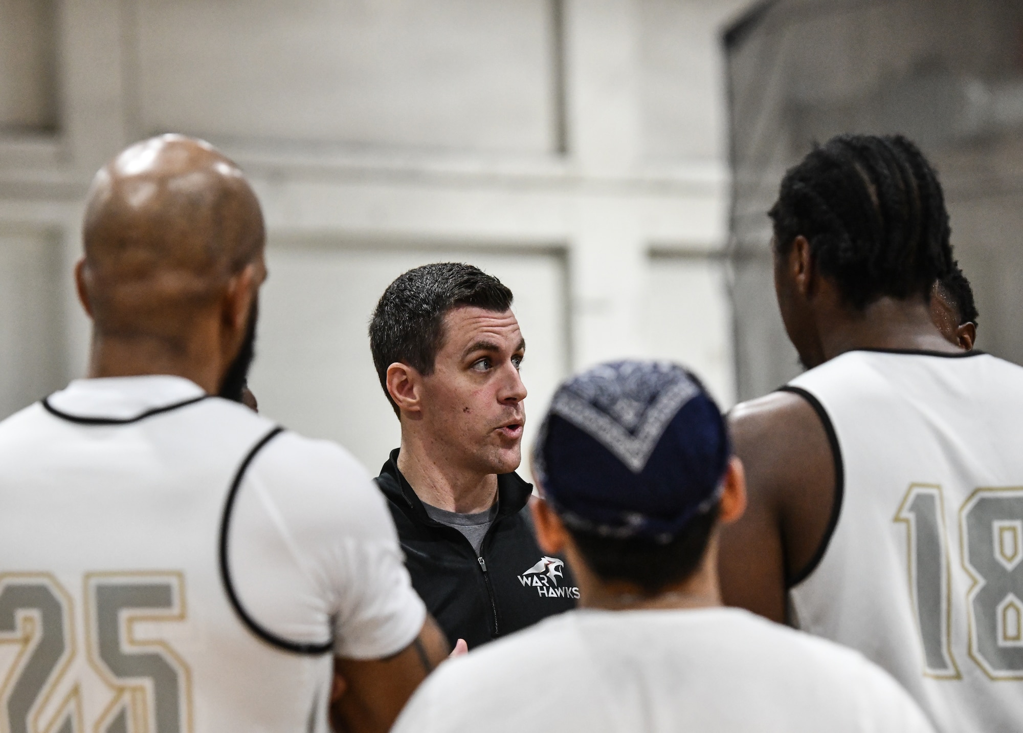 Offutt Warhawks Head Coach Capt. Christopher Cook rallys the team during a timeout at the Offutt Air Force Base Field House on Feb. 1, 2025. Offutt defeated Peterson Space Force Base in overtime, 88-87. (U.S. Air Force photo by Chad Watkins)