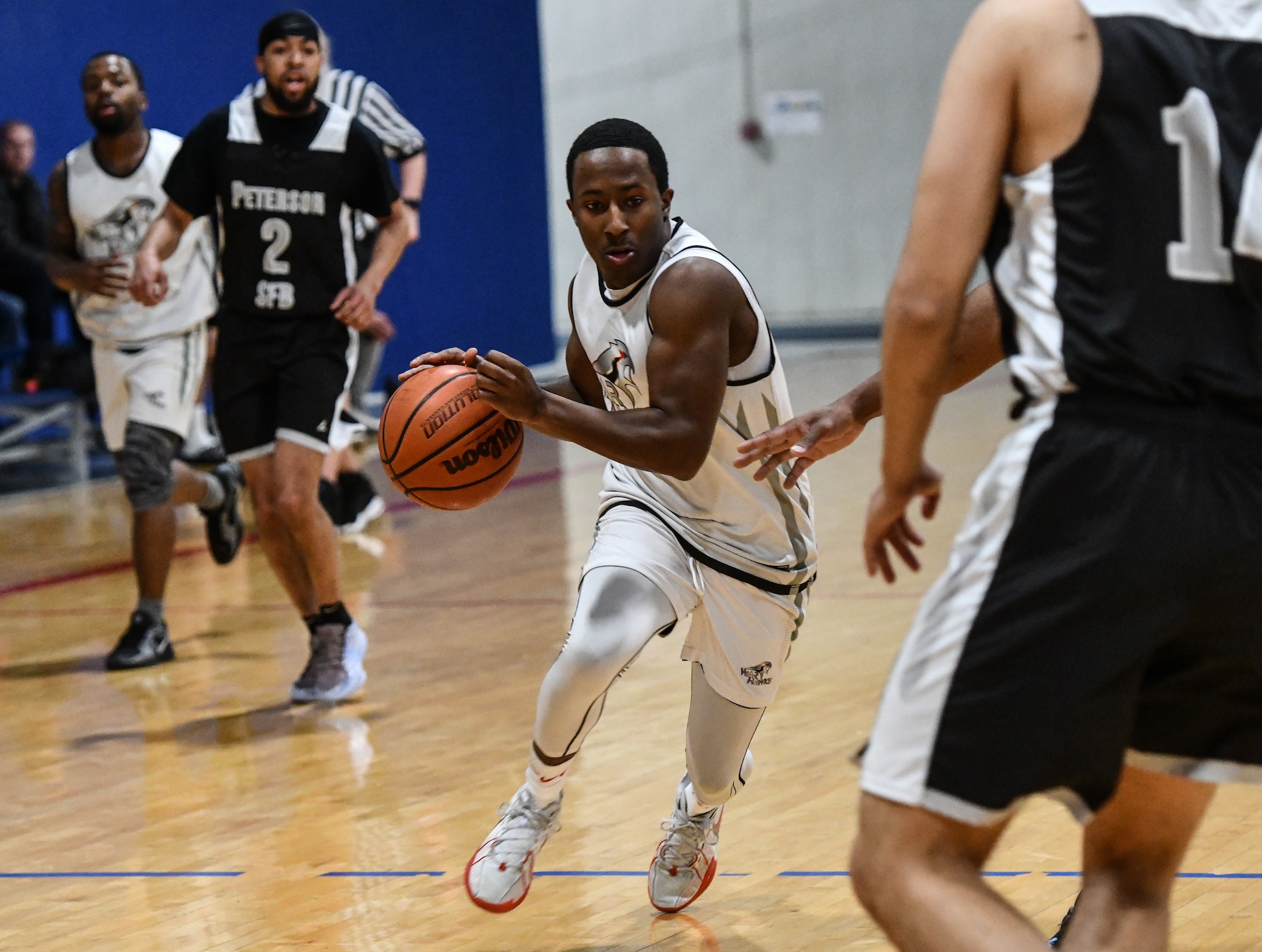 Senior Airman Jadien Spivey, 55th Aircraft Maintenance Squadron, drives to the hoop at the Offutt Air Force Base Field House on  Feb. 1, 2025.  Offutt defeated Peterson Space Force Base in overtime, 88-87. (U.S. Air Force photo by Chad Watkins)