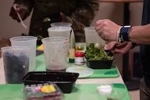 U.S. Air Force Chief Master Sgt. Thomas Gunnell, 492nd Special Operations Wing command chief, mixes a salad with homemade dressing at Hurlburt Field, Florida, Feb. 11, 2025.