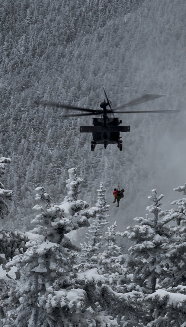 Sgt. 1st Class Ethan Major, a flight medic with the New Hampshire Army National Guard, and stricken hiker, Patrick Bittman, are hoisted into a Black Hawk helicopter Dec. 19, 2024, during a successful search and rescue on Franconia Ridge.