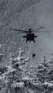 Sgt. 1st Class Ethan Major, a flight medic with the New Hampshire Army National Guard, and stricken hiker, Patrick Bittman, are hoisted into a Black Hawk helicopter Dec. 19, 2024, during a successful search and rescue on Franconia Ridge.