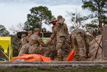 Airmen shovel sand.
