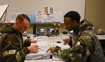 Airmen read over a checklist.