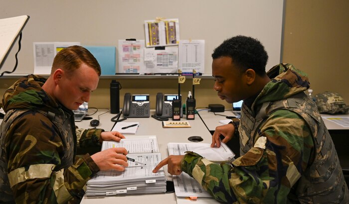 Airmen read over a checklist.
