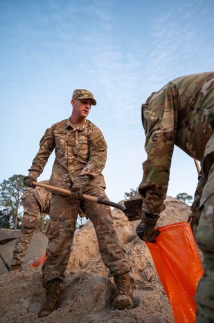 An Airman shovels sand.