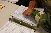 An Airman reads through a binder.