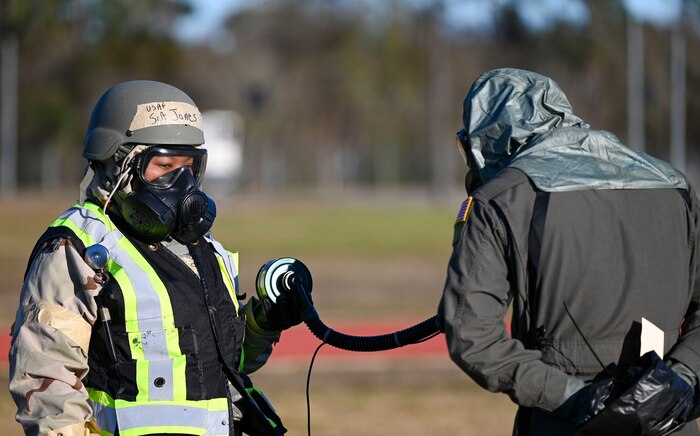 An Airmen checks a pilot's gas mask.