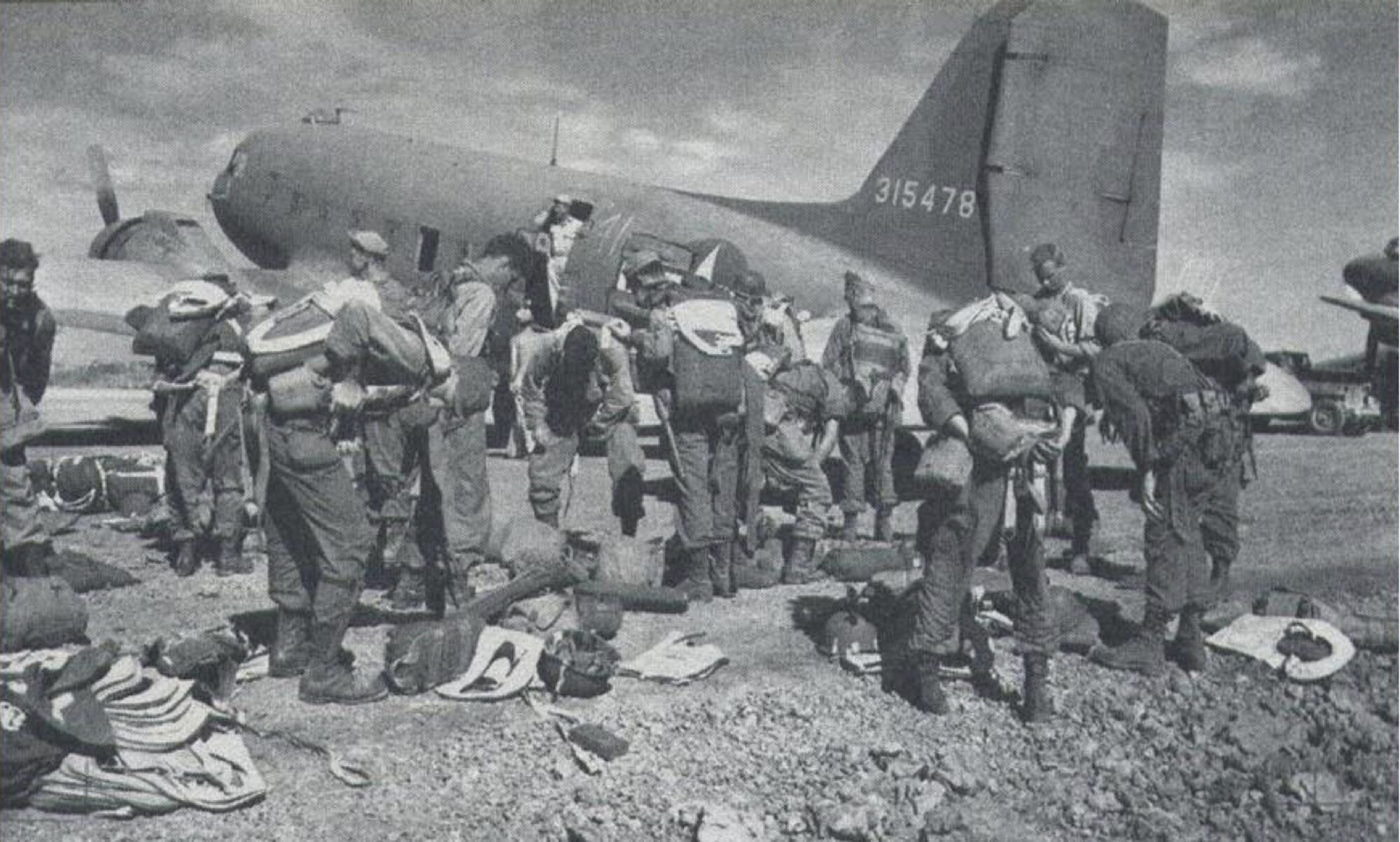 U.S. Army Signal Corps depicts 511th Parachute Infantry Regiment paratroopers staging gear in Mindoro, Philippines, Feb. 3, 1945. The 511th PIR, part of the 11th Airborne Division, prepared for a mass combat airdrop with the 317th Troop Carrier Group over Tagaytay Ridge in Luzon, Philippines, in support of the liberation of the Japanese-occupied capital, Manila. The joint cooperation to liberate and defend the Philippines was critical to U.S. victory in the Pacific Theater. (Photo by Courtesy Photo)