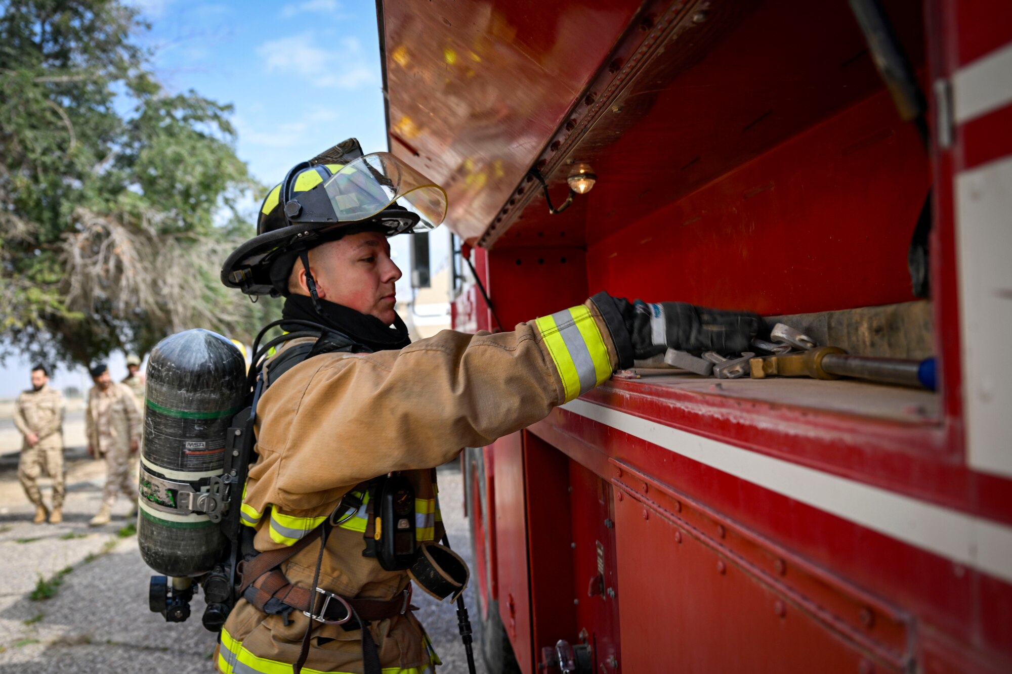 A firefighter sorts through tools.
