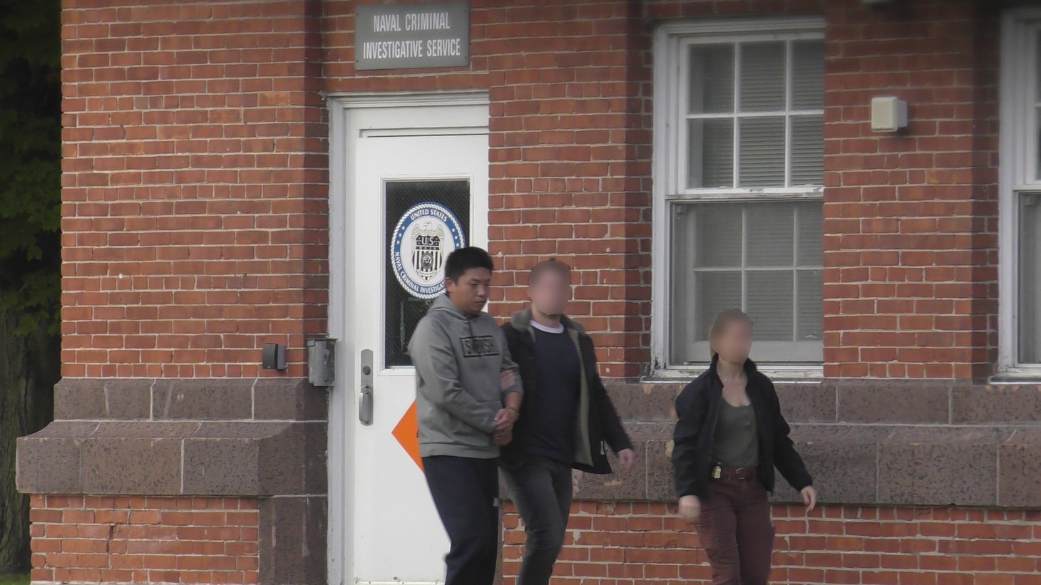 NCIS Special Agents escort Pang after arresting him for plotting to attack Naval Station Great Lakes.