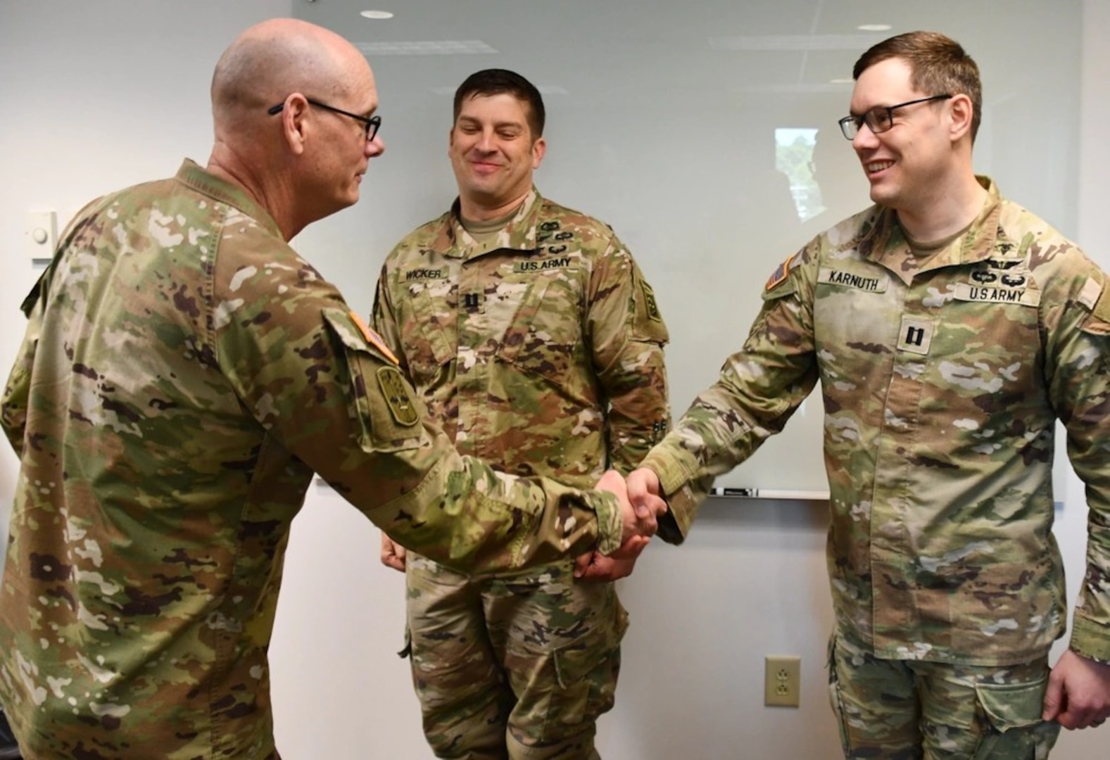 U.S. Army Medical Readiness Command, East Commanding General and Director Defense Health Network East, Brig. Gen. Lance Raney presented 1st Brigade Combat Team Senior Physician Assistant Capt. Timothy Karnuth, with a coin during his recent visit to Womack Army Medical Center for his efforts in spearheading early implementation of My Military Health.