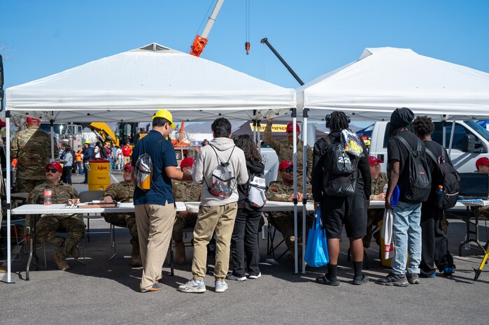 A group of students are lined up at the U.S. Air Force 850th RHS Construction Career Day booth.