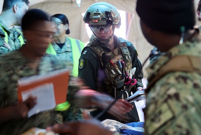 Lt. Stephanie Ryan, a flight nurse with the Role 2 En-Route Care System (ERCS) 11-15 San Diego, briefs medical personnel with Expeditionary Medical Facility (EMF) 150 Alpha on a simulated patient’s information at the casualty receiving area following a safe transport during an EMF training and Operational Readiness Evaluation (ORE) at Naval Expeditionary Medicine Warfighter Development Center (NEMWDC), Camp Pendleton, Calif., Feb. 15-28. The training scenarios incorporated the ERCS platform, enhancing the realism the expeditionary medicine (EXMED) systems may experience during operations. The ERCS is a two-person team that provides personnel, equipment, and consumables for uninterrupted continuation of patient care during movement. The EMF is a role 3 platform, designed to provide in-theater hospitalization with higher hold capacity, up to a 150-beds.