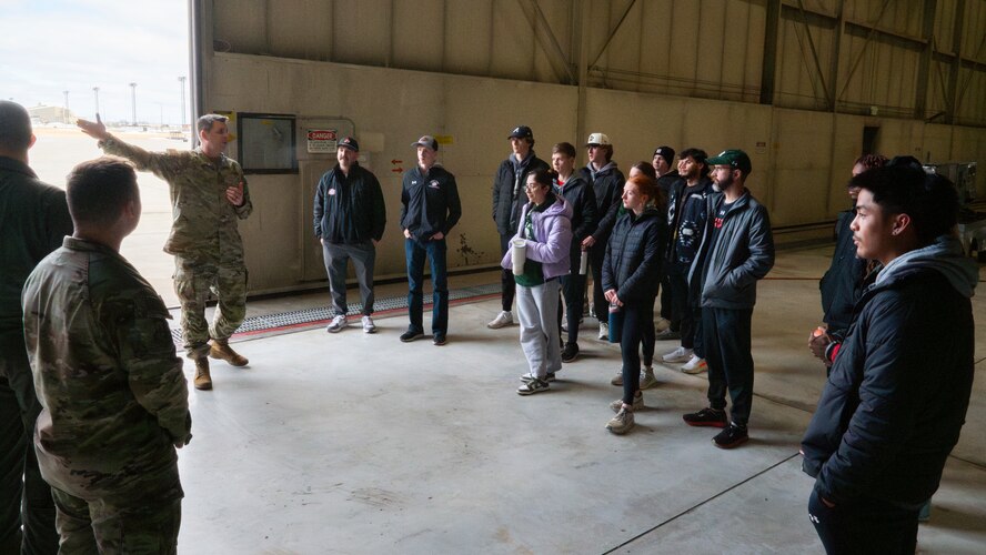 Senior Master Sgt. Thomas Pittman, a Weapons Standardization Superintendent from the 5th Maintenance Group, greets the Minot State University Track & Field Team during a tour at Minot Air Force Base, North Dakota, March 4, 2025. The students had the opportunity to tour a B-52H Stratofortress and learn about the mission of Minot’s Airmen. (U.S. Air Force photo by Senior Airman Kendra A. Ransum)