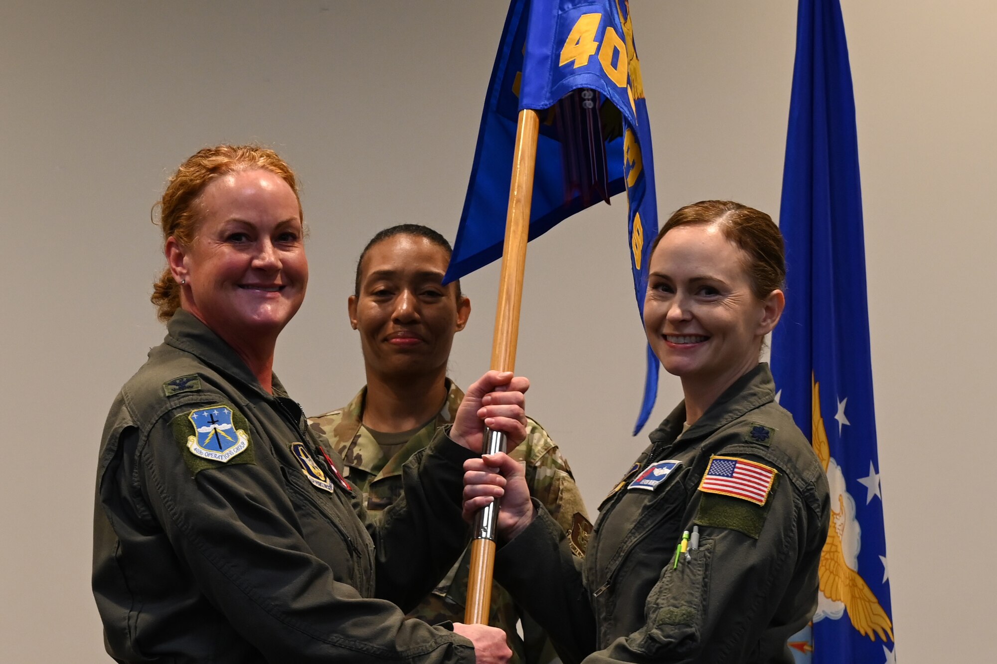 Granderson passes 403rd Operations Support Squadron guidon to Burton as the incoming commander.