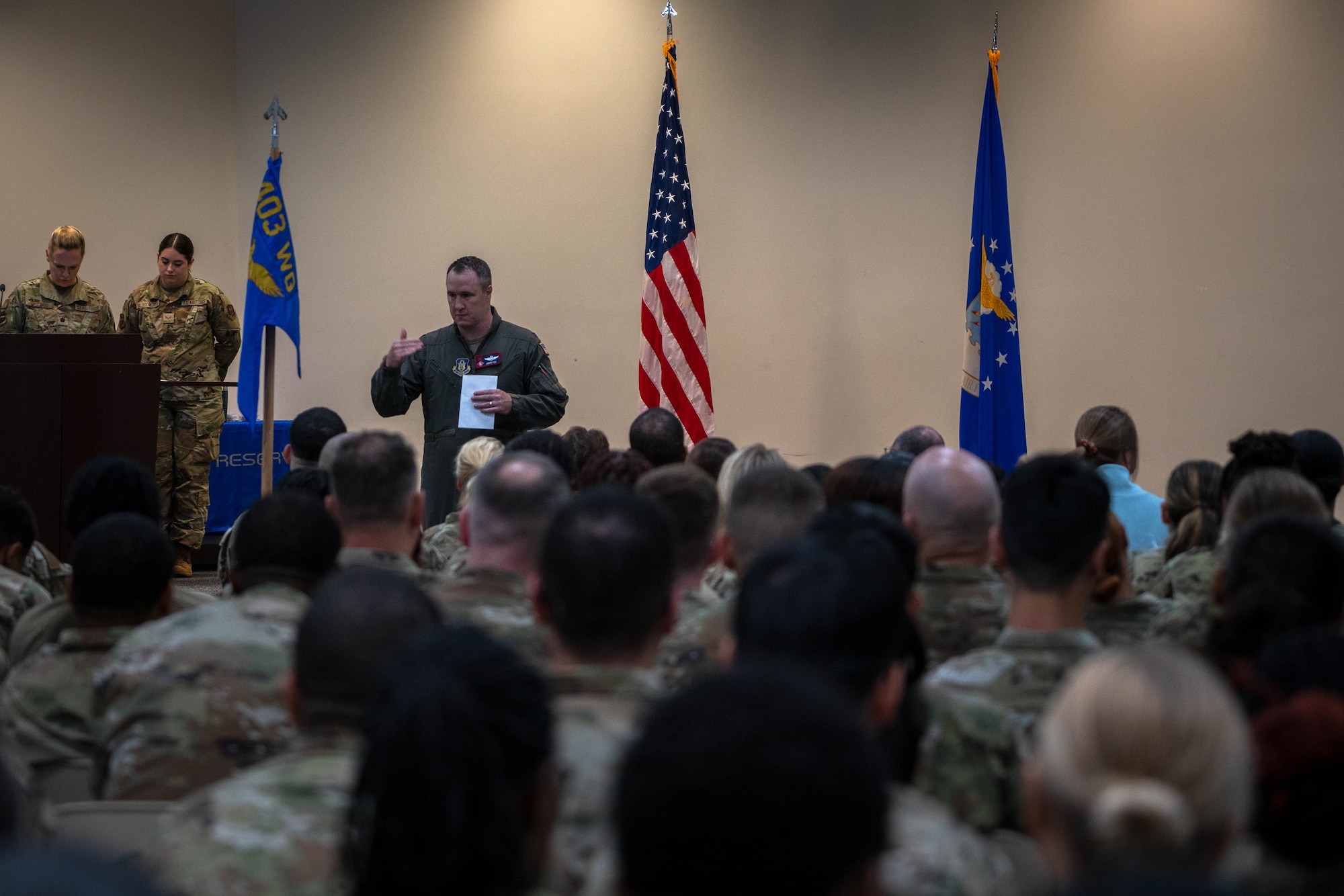 Colonel addressing wing members during a commander's call.