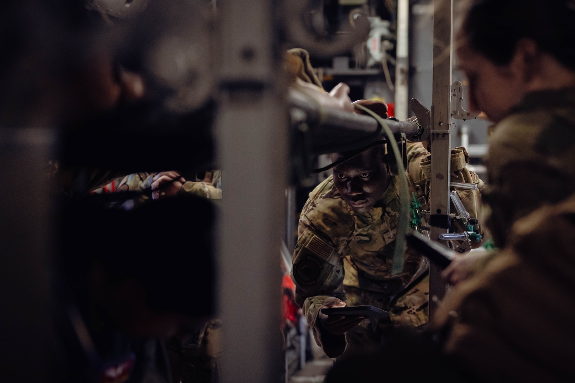 An airman observes his crew of AE Airmen completing CPR training on a fuselage trainer.