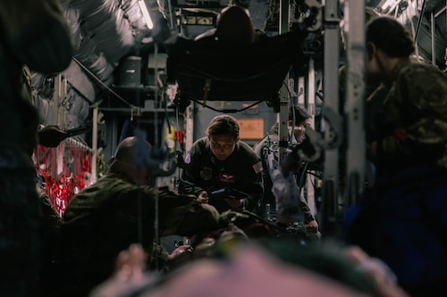 An airman in a flight suit simulates CPR during a training exercise.