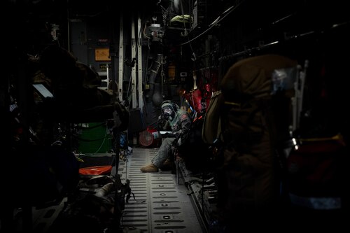 An airman with CBRN gear on looks around a fuselage trainer.