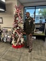 U.S. Army Soldier in uniform poses with office Christmas Tree