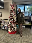 U.S. Army Soldier in uniform poses with office Christmas Tree