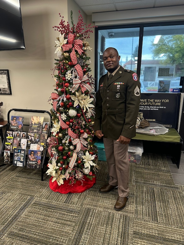 U.S. Army Soldier in uniform poses with office Christmas Tree