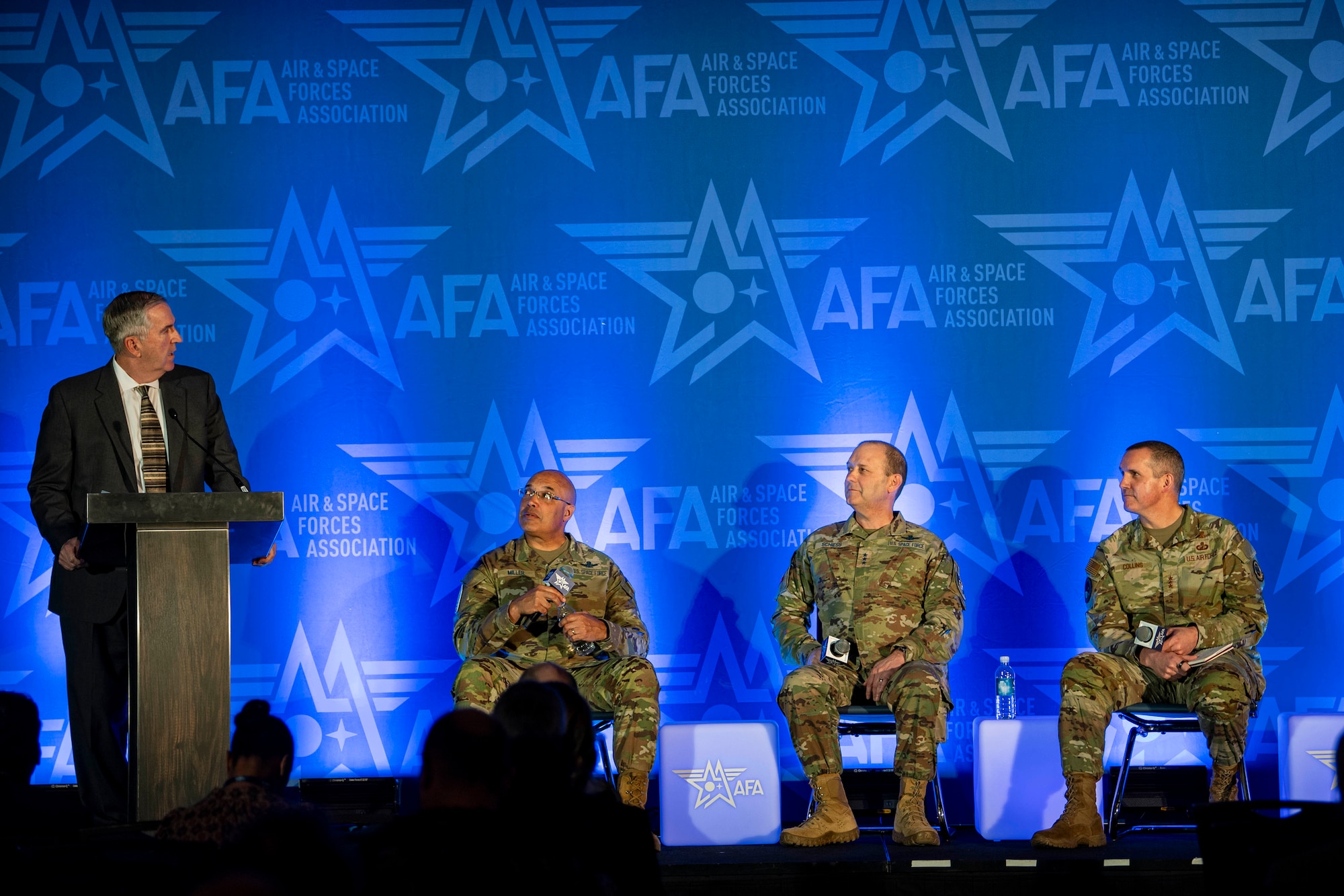 Four people take the stage at a conference.