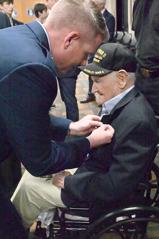 A general pins a gold star family pin to a 101-year-old man