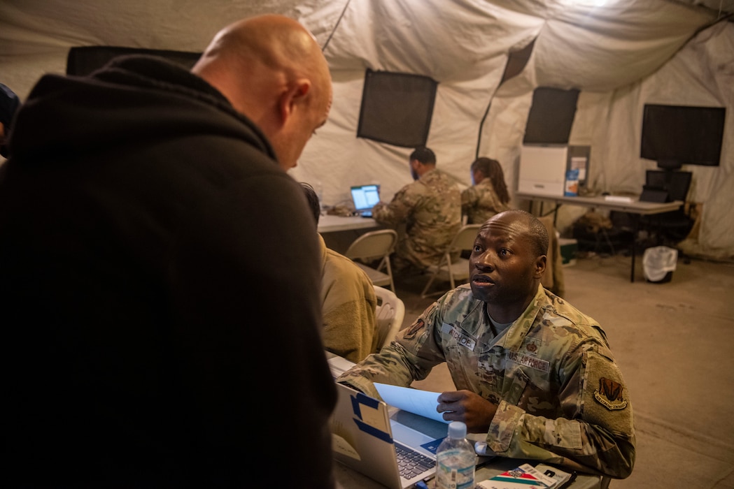 U.S. Air Force Tech. Sgt. Francis Atchoe, 51st Force Support Squadron augmentee right, in-processes an augmentee for exercise Freedom Shield 25 at Osan Air Base, Republic of Korea, March 1, 2025.