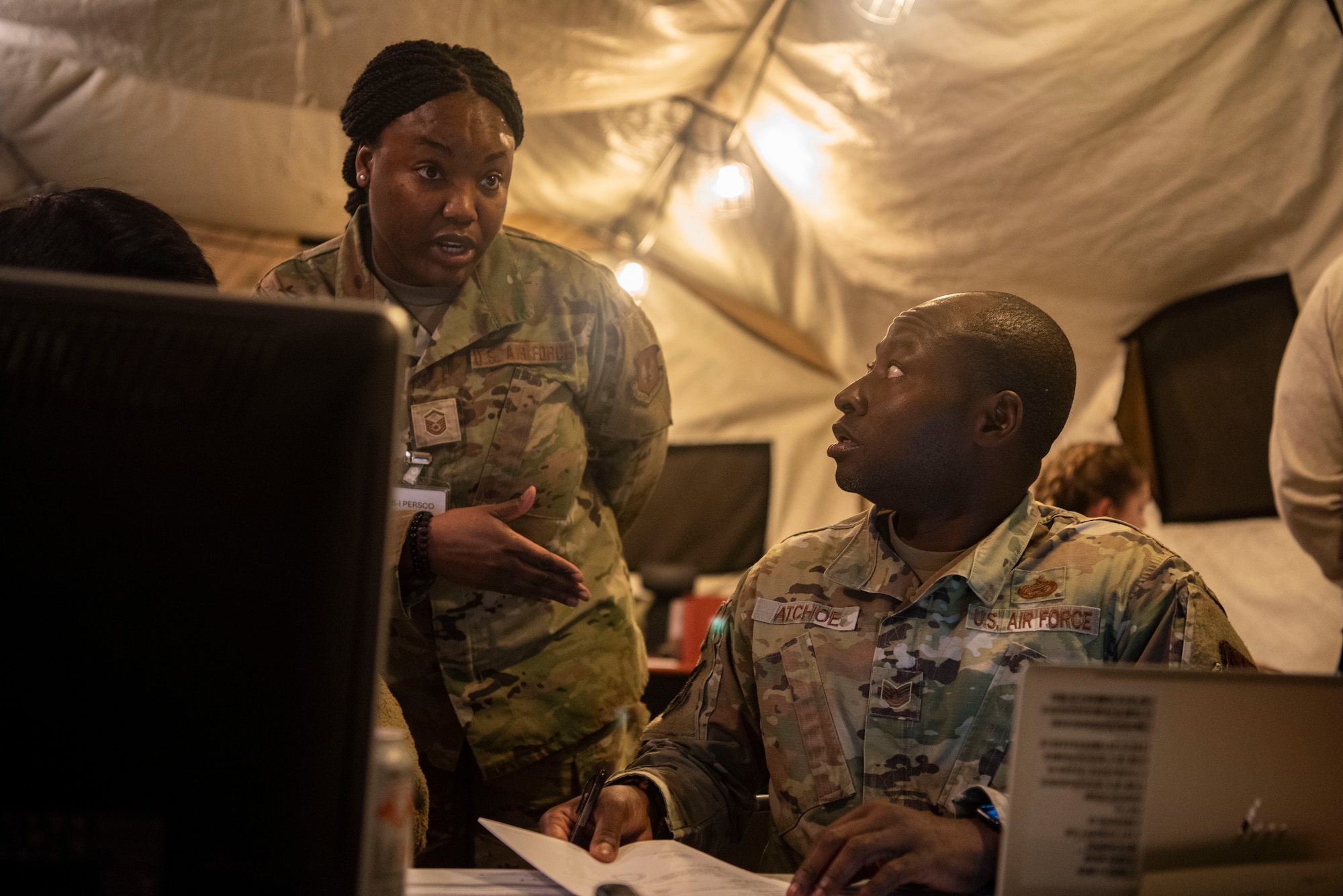 U.S. Air Force Master Sgt. Monique Walker, 51st Force Support Squadron augmentee, left, gives guidance to U.S. Air Force Tech. Sgt. Francis Atchoe, 51st FSS augmentee, about the in-processing of augmentees for exercise Freedom Shield 25 at Osan Air Base, Republic of Korea, March 1, 2025.