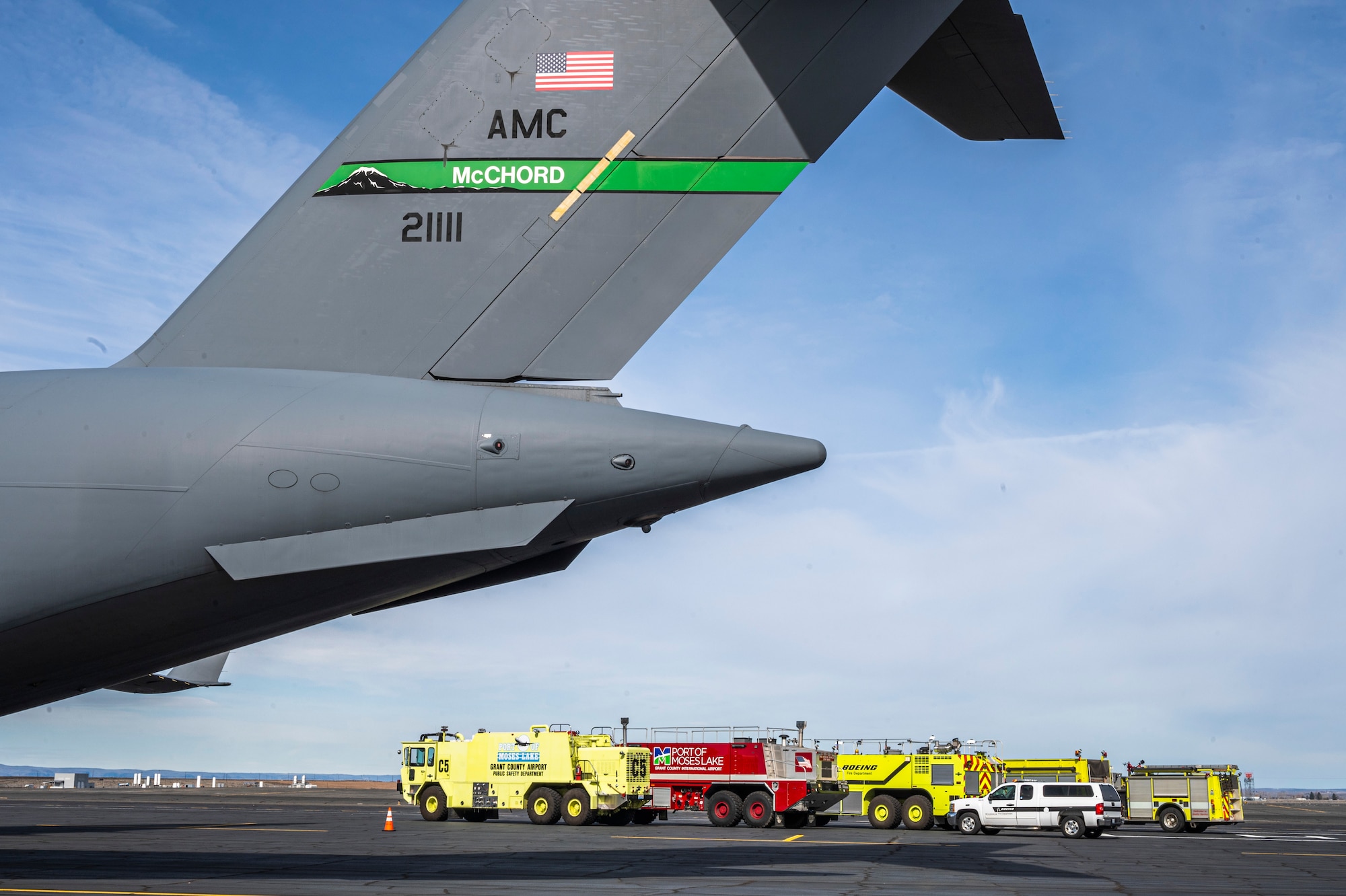 Fire department vehicles from Grant County, the Port of Moses Lake, and Boeing park alongside a 62d Airlift Wing C-17 Globemaster III staged for a midair collision avoidance brief and aircraft tour given to Big Bend Community College aviation program students in Moses Lake, Washington, March 7, 2025.