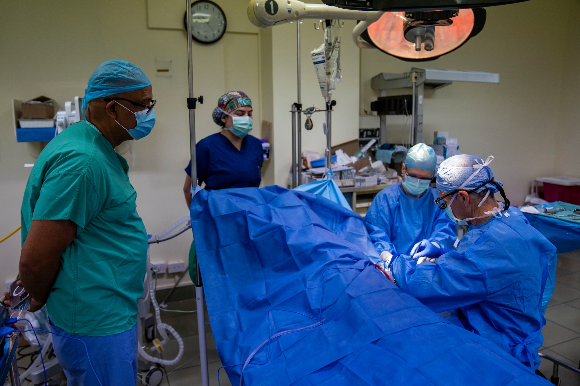 Dr. Richard Burt, a general surgeon at St. Jude Hospital, watches U.S. Air Force Col. William Knoll, 349th Medical Squadron commander and vascular surgeon, and Tech. Sgt. Michael Jones, 349th Medical Squadron surgical technician, perform a Arteriovenous Fistula procedure on a patient during the Lesser Antilles Medical Assistance Team mission at St. Jude Hospital in Vieux Fort, Saint Lucia, March 4, 2025. The LAMAT mission allows U.S. and host nation medical professionals a unique opportunity to work together, promoting global health, readiness, and ultimately benefiting both military personnel and the citizens of the host nation. (U.S. Air Force photo by Andrea Jenkins)