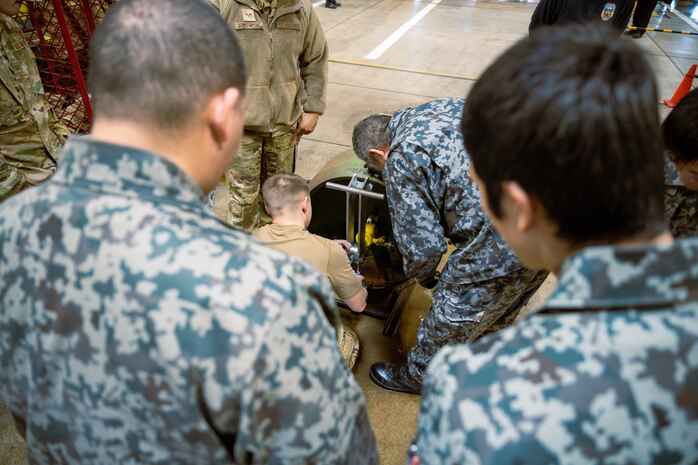 Japan Air Self-Defense Force firefighters observe a hazardous materials containment demonstration by U.S. Air Force members assigned to the 35th Fighter Wing during a bilateral HAZMAT training exercise at Misawa Air Base, Japan, March 7, 2025. The training reinforced knowledge-sharing and strengthened emergency response collaboration by allowing participants to familiarize themselves with each other’s equipment, refine joint operational procedures, and improve their ability to respond swiftly and effectively to hazardous material incidents. (U.S. Air Force photo by Senior Airman William Rodriguez)