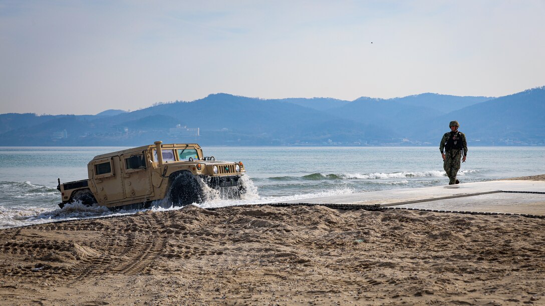 A High Mobility Multi-Purpose Wheeled Vehicle from the United States Naval Ship Dahl (T-AKR 312) departs an Improved Navy Lighterage System during an instream offload operation as part of Freedom Banner 25 at the Republic of Korea Marine Corps Base Pohang, South Korea.



Freedom Banner 25, the first phase of the Korean Marine Exchange Program (KMEP) 25.1, enhances U.S.-Republic of Korea (ROK) interoperability and validates Maritime Prepositioning Force (MPF) operations to sustain forces in austere environments. Led by the 3rd Marine Logistics Group, the exercise focuses on offloading prepositioned equipment from MPF ships—pre-loaded in Jacksonville, Florida, by Blount Island Command—through both instream and pier-side offloads to support the III Marine Expeditionary Force (MEF) training in South Korea. These logistics operations refine expeditionary sustainment capabilities, ensuring forces can rapidly deploy and operate in contested environments while supporting Distributed Maritime Operations (DMO) and Expeditionary Advanced Base Operations (EABO). As the exercise concludes, forces will transition to Freedom Shield 25, further strengthening regional security and readiness.