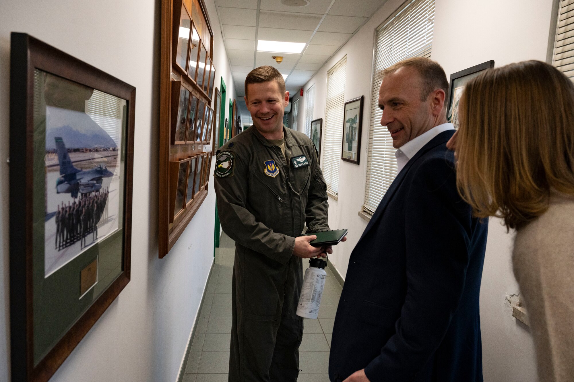 A man looks at photos on a wall.