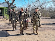 Four trainees carry a medical litter with a mannequin
