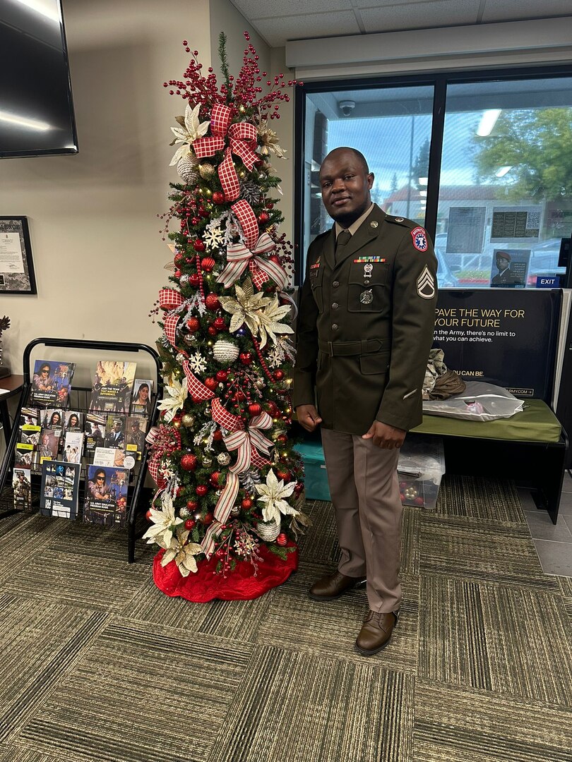 U.S. Army Soldier in uniform poses with office Christmas Tree