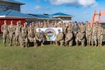 The Lesser Antilles Medical Assistance Team (LAMAT) 2025 stand outside Owen King European Union (OKEU) Hospital for a group photo at Castries, Saint Lucia, Feb. 26, 2025. LAMAT stands as a symbol of partnership through medical readiness, offering real-world benefits to achieve positive outcomes through collaboration with partner nations. (US Air Force photo by Tech. Sgt. Ryan Green)
