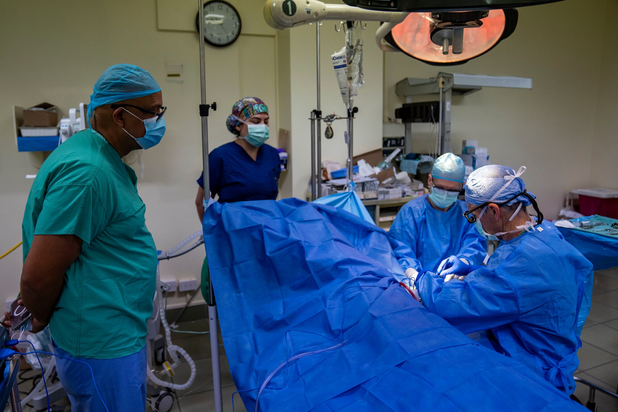 Dr. Richard Burt, a general surgeon at St. Jude Hospital, watches U.S. Air Force Col. William Knoll, 349th Medical Squadron commander and vascular surgeon, and Tech. Sgt. Michael Jones, 349th Medical Squadron surgical technician, perform a Arteriovenous Fistula procedure on a patient during the Lesser Antilles Medical Assistance Team mission at St. Jude Hospital in Vieux Fort, Saint Lucia, March 4, 2025. The LAMAT mission allows U.S. and host nation medical professionals a unique opportunity to work together, promoting global health, readiness, and ultimately benefiting both military personnel and the citizens of the host nation. (U.S. Air Force photo by Andrea Jenkins)