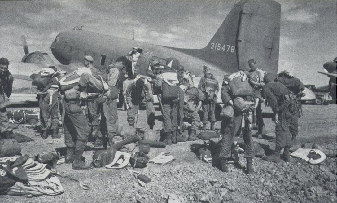 U.S. Army Signal Corps depicts 511th Parachute Infantry Regiment paratroopers staging gear in Mindoro, Philippines, Feb. 3, 1945. The 511th PIR, part of the 11th Airborne Division, prepared for a mass combat airdrop with the 317th Troop Carrier Group over Tagaytay Ridge in Luzon, Philippines, in support of the liberation of the Japanese-occupied capital, Manila. The joint cooperation to liberate and defend the Philippines was critical to U.S. victory in the Pacific Theater. (Photo by Courtesy Photo)