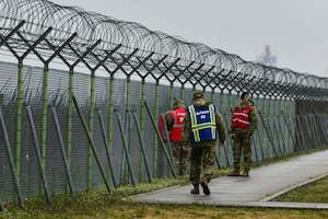 Airmen inspect a fence