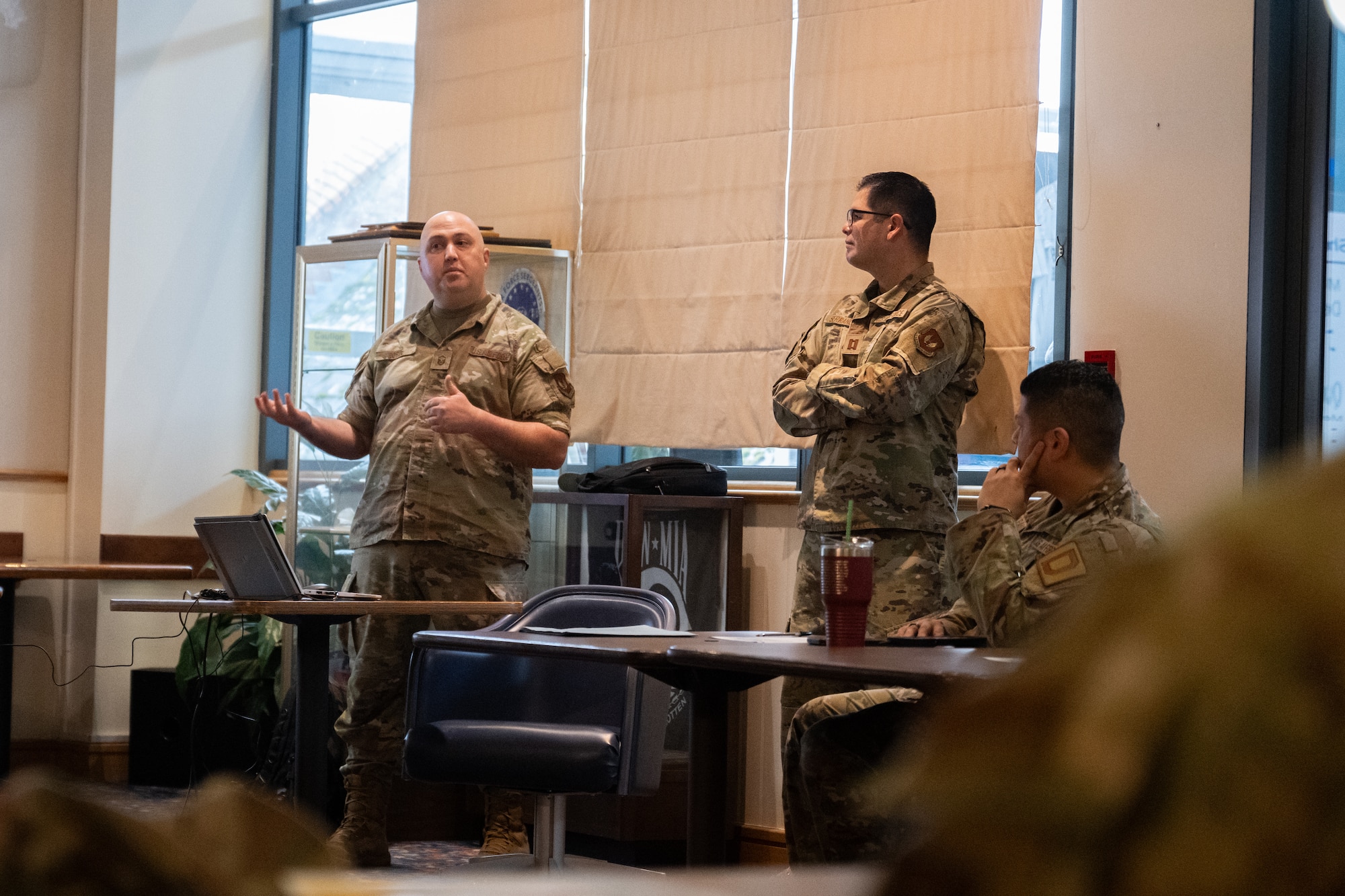 U.S. Air Force Master Sgt. Philip Borde, left, 48th Medical Group independent duty medical technician, and Capt. Miguel Serrano, 48th MDG physician assistant, brief Team Mildenhall first sergeants about new shaving waiver guidance at RAF Mildenhall, England, Feb. 26, 2025.